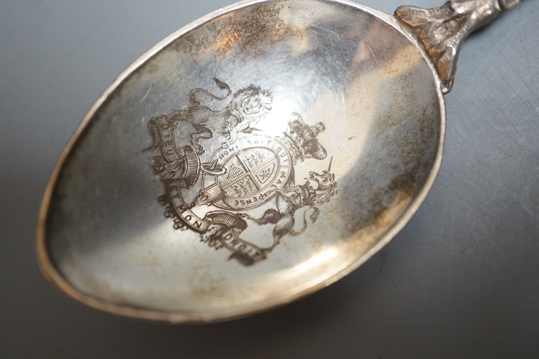 A late Victorian silver and enamelled spoon, with rustic stem and Prince of Wales feathers terminal, the bowl engraved with the Royal Coat of Arms, Saunders & Shepherd, London, 1896, 20.2cm, gross 43 grams.